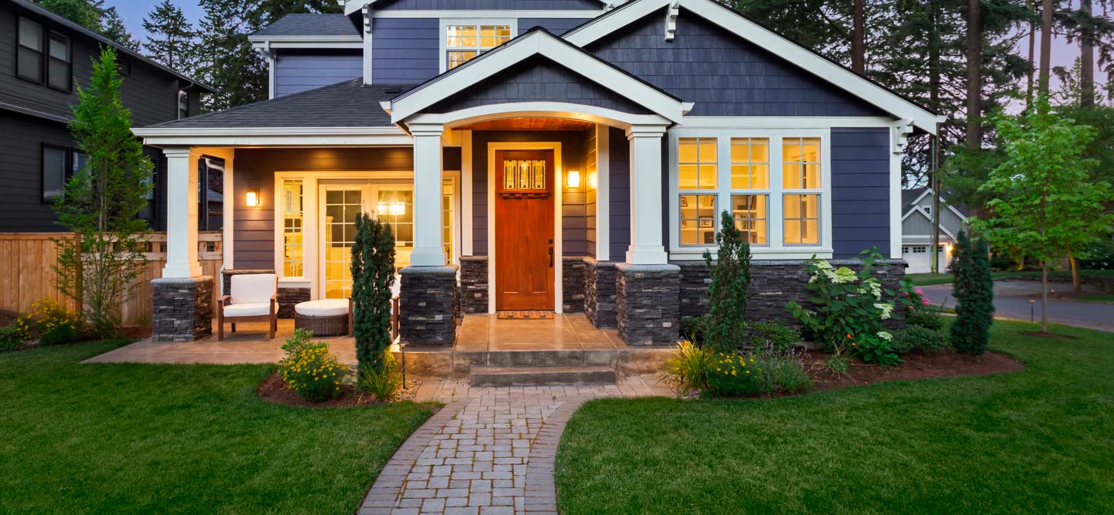 A picture of a nice modern house and lawn with stone pathway leading up to door