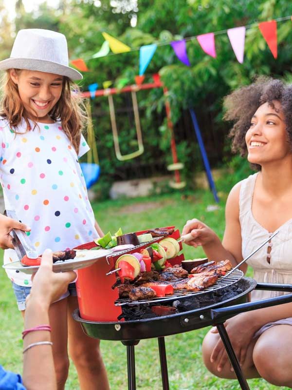 A picture of a family having a cookout in their yard